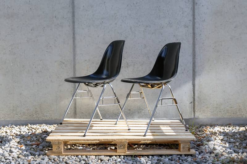 Gebrauchte St&uuml;hle, die professionell aufgefrischt wurden, stehen draussen auf einem Palett